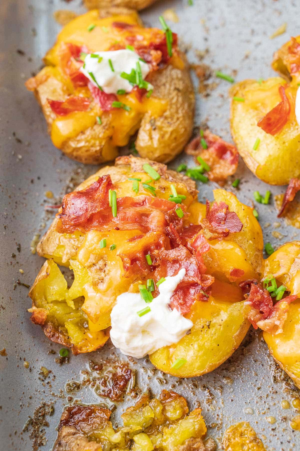 Close-up photo of Loaded Smashed Potatoes on a baking sheet.