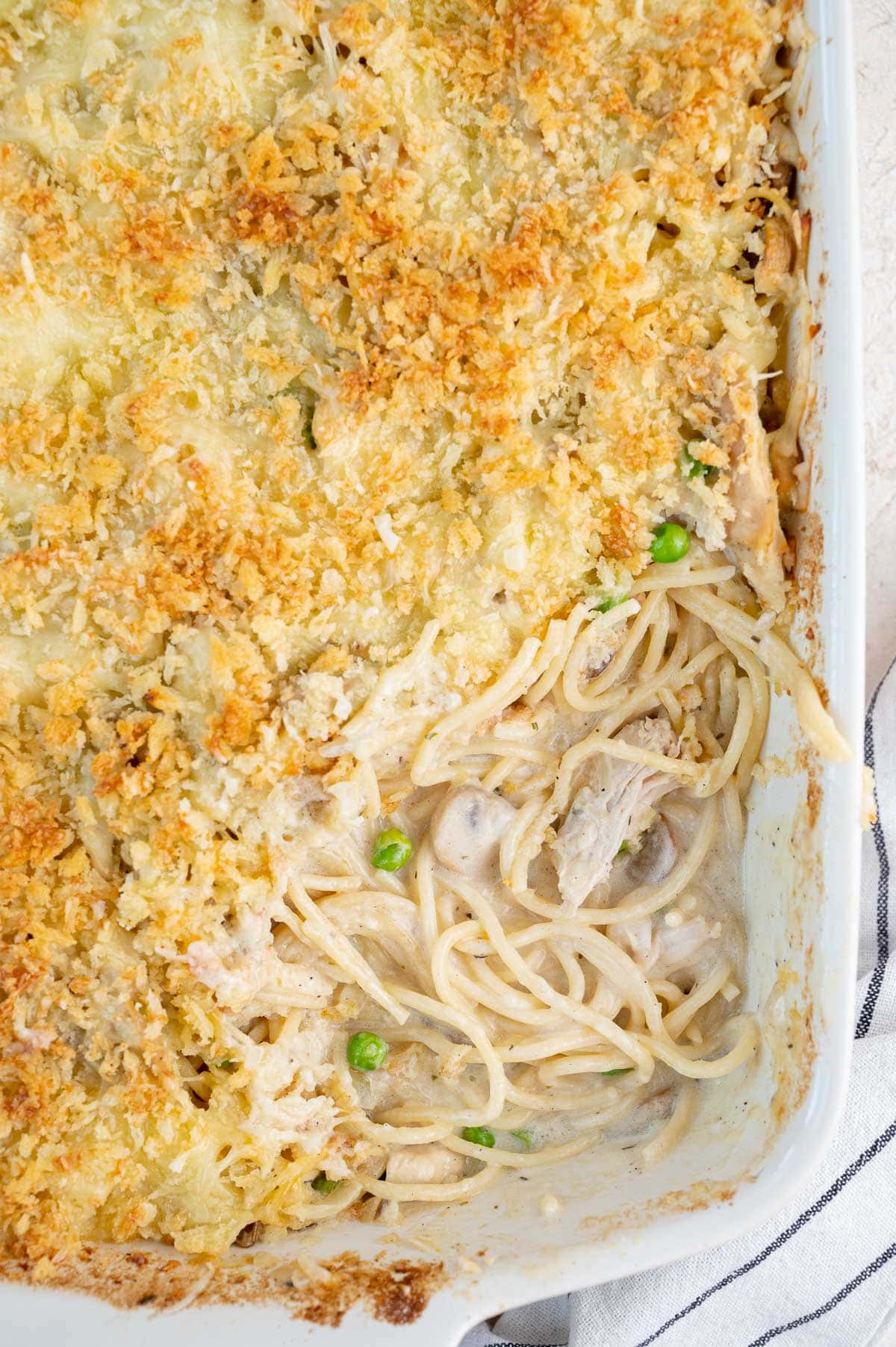 Turkey Tetrazzini with a serving missing in a white baking dish.