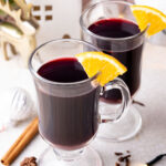 Two glasses with Glühwein on a grey stone board.