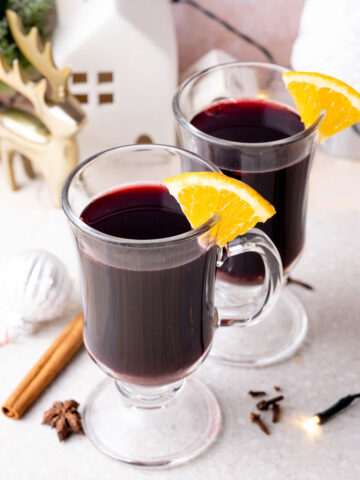 Two glasses with Glühwein on a grey stone board.
