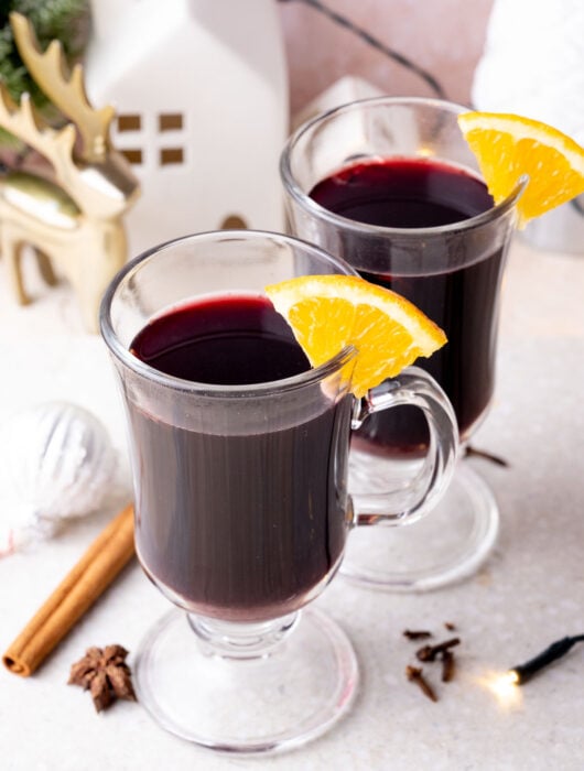 Two glasses with Glühwein on a grey stone board.