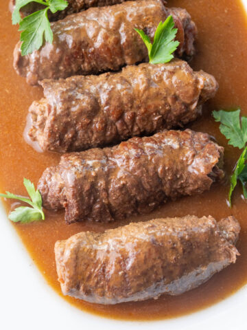Rouladen with gravy on a white plate.