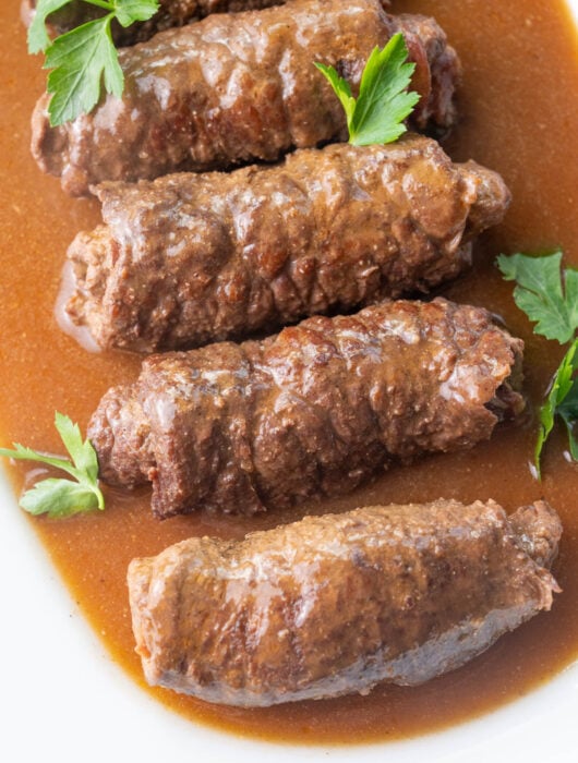 Rouladen with gravy on a white plate.