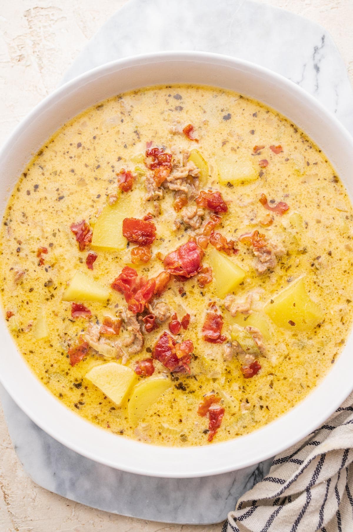 Cheeseburger chowder soup in a white bowl. 