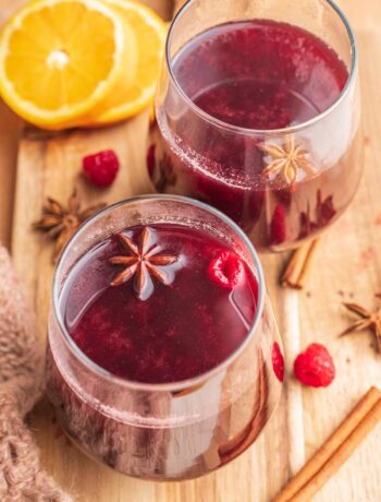 Two glasses with mulled wine on a wooden board.