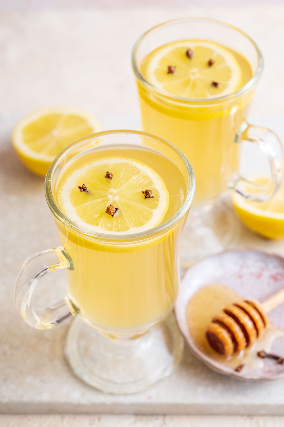 Two glasses with hot toddy. Lemons and honey in the background.