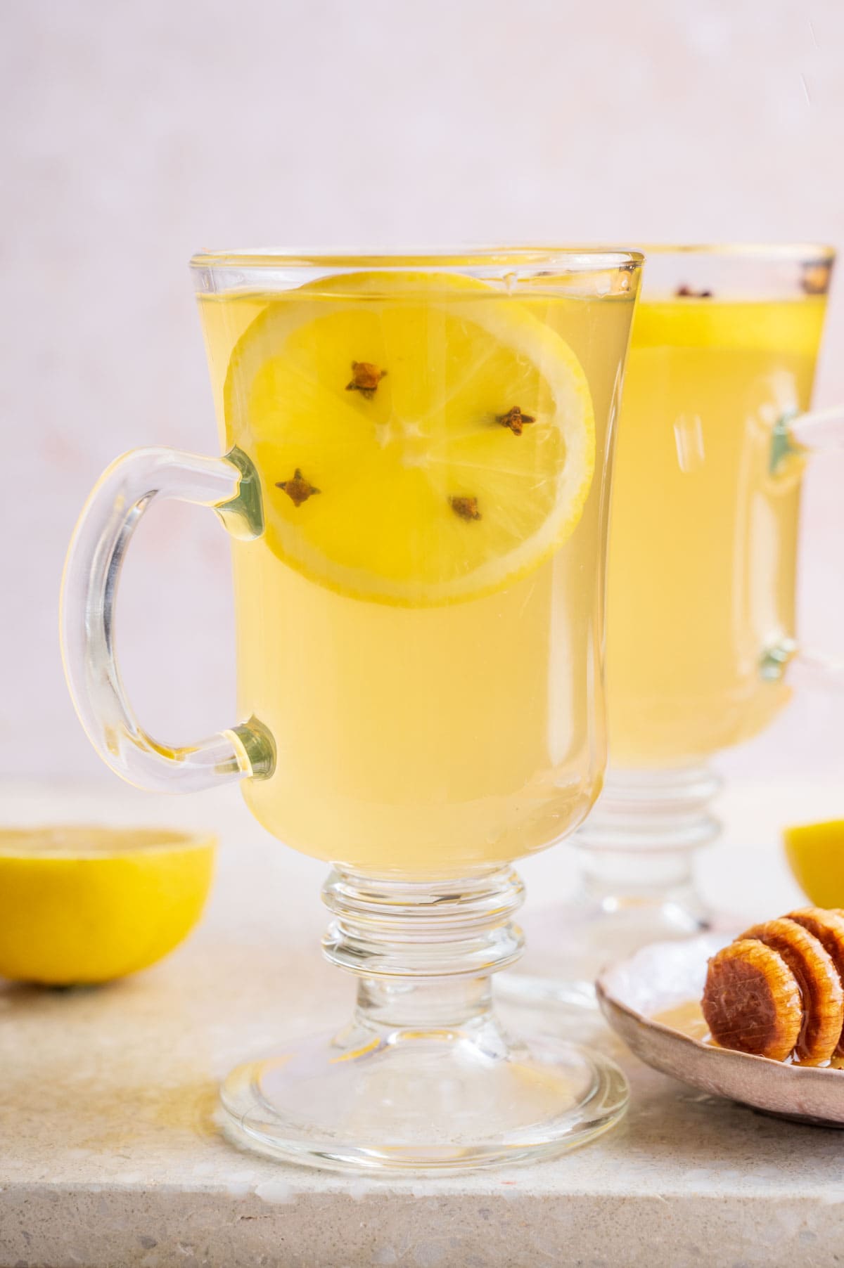 Two glasses with hot toddy. Lemons and honey in the background.