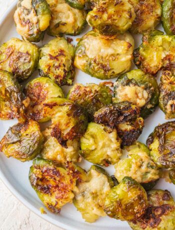 Smashed brussel sprouts on a white plate.