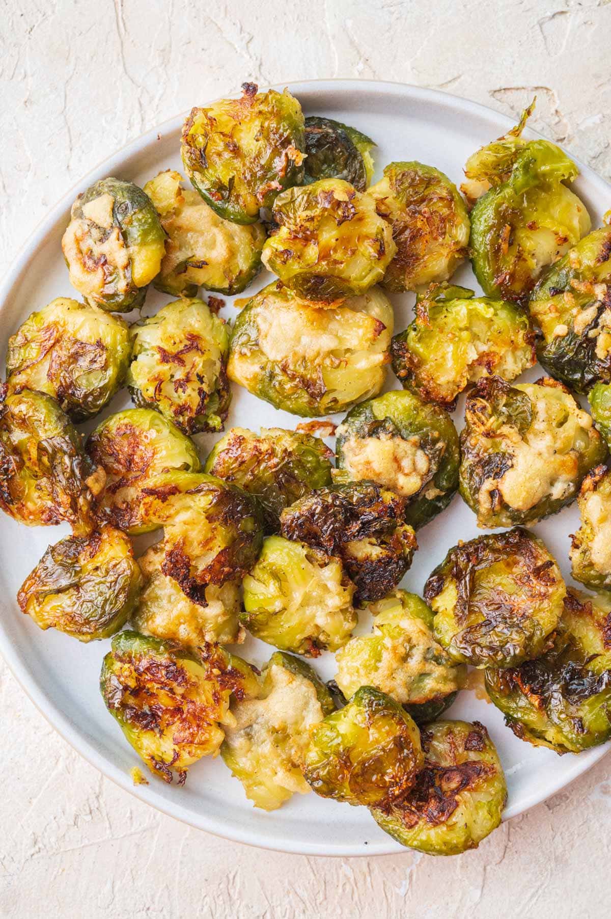 Smashed Brussel Sprouts on a white plate.