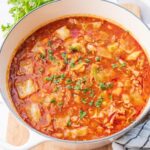 Cabbage roll soup in a white pot.