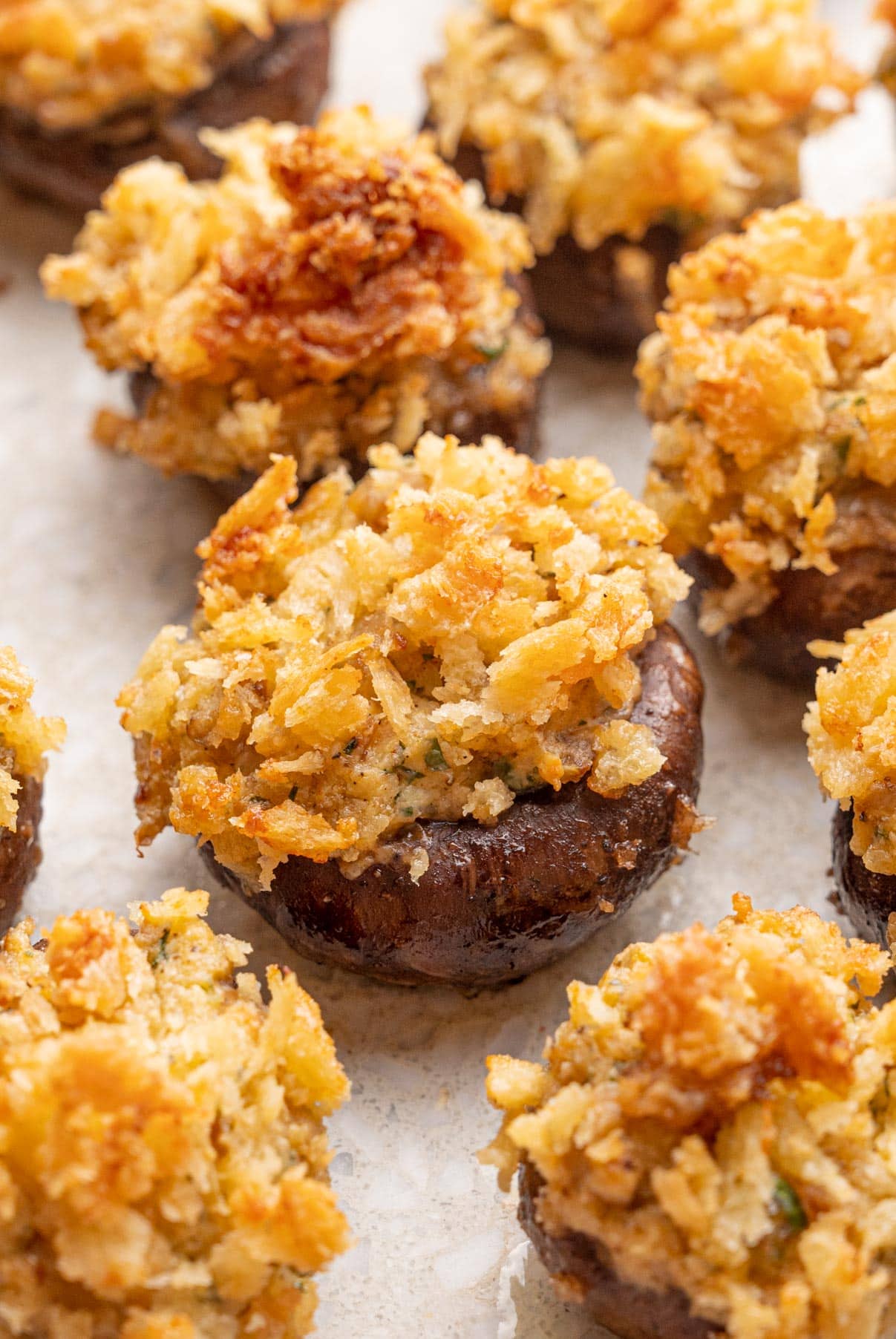 A close up photo of stuffed mushrooms on a stone board.