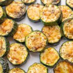 Baked parmesan zucchini on a white plate.