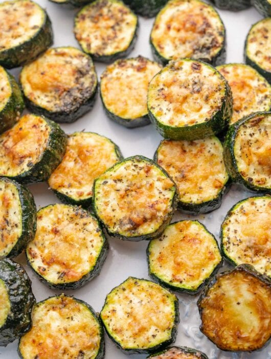 Baked parmesan zucchini on a white plate.