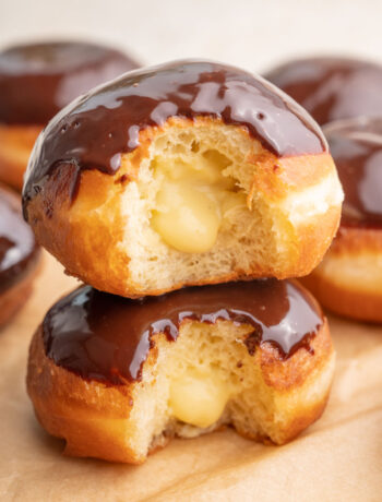 Two Boston cream donuts stack on each other.