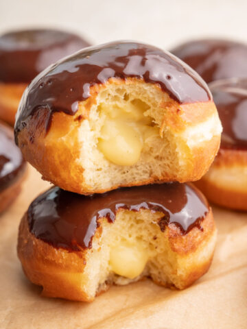 Two Boston cream donuts stack on each other.