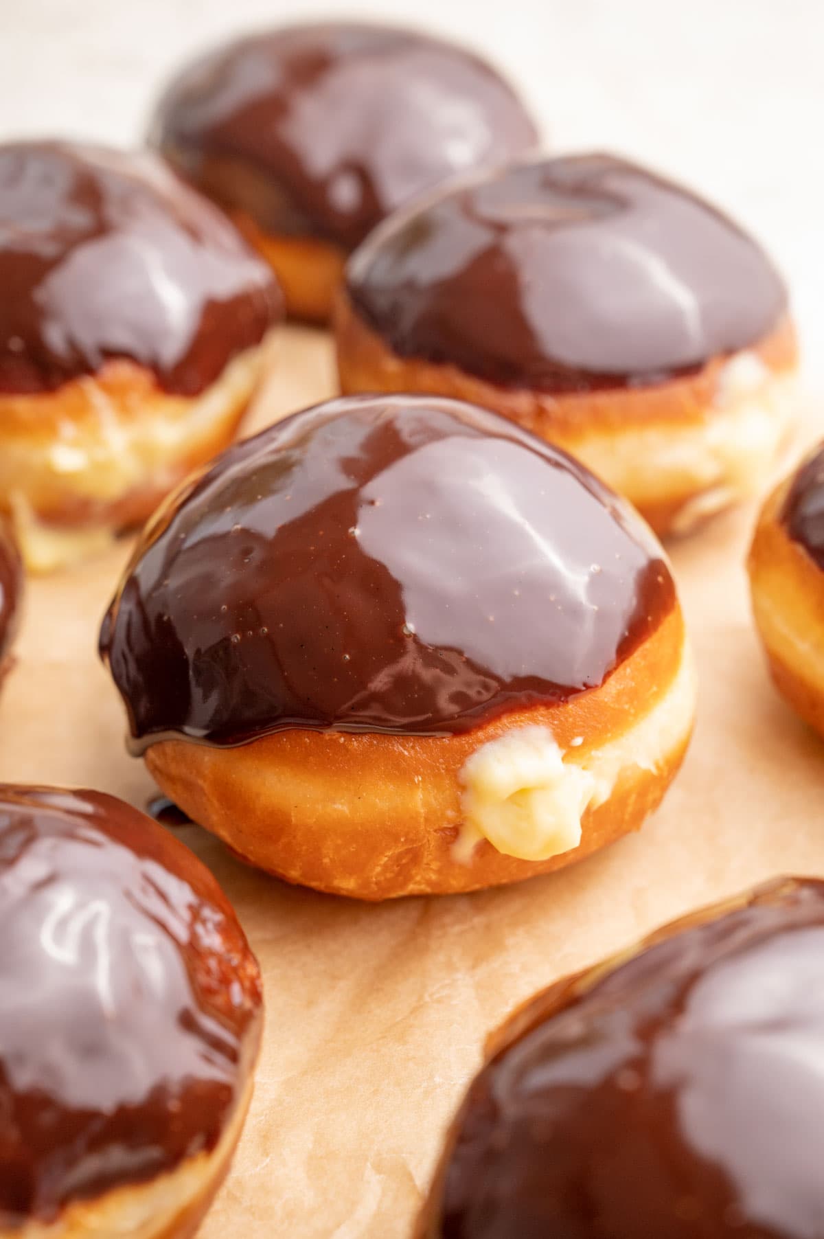 Boston cream donuts on a piece of parchment paper.