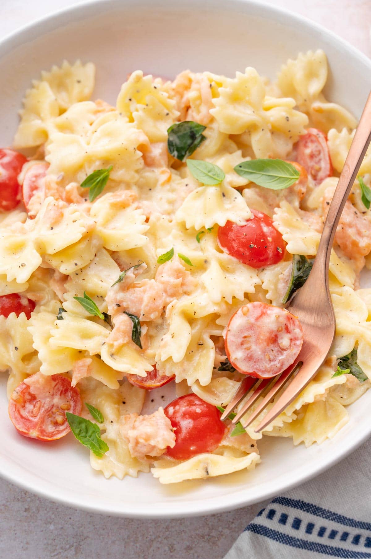 Smoked salmon pasta on a white plate.