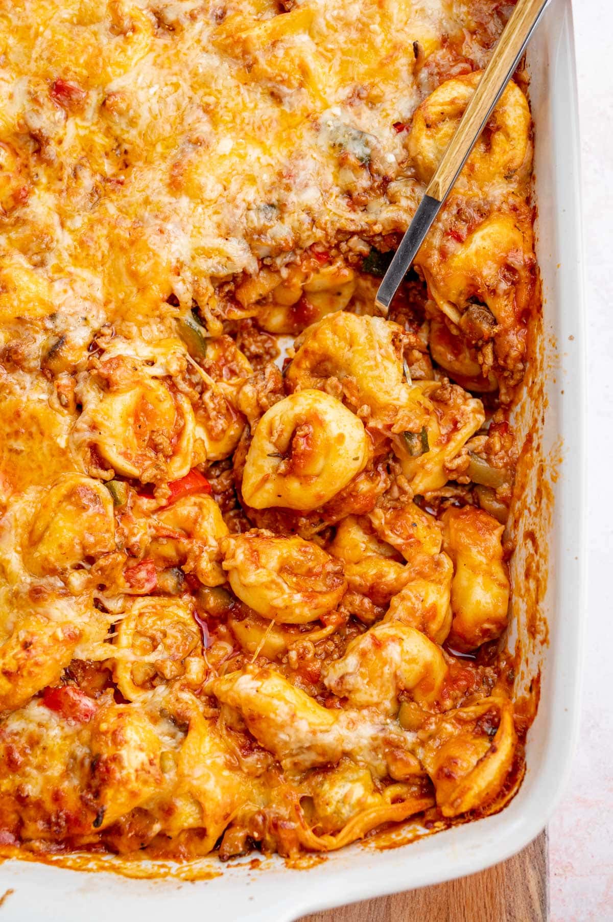 A close up photo of tortellini bake in a white casserole dish.