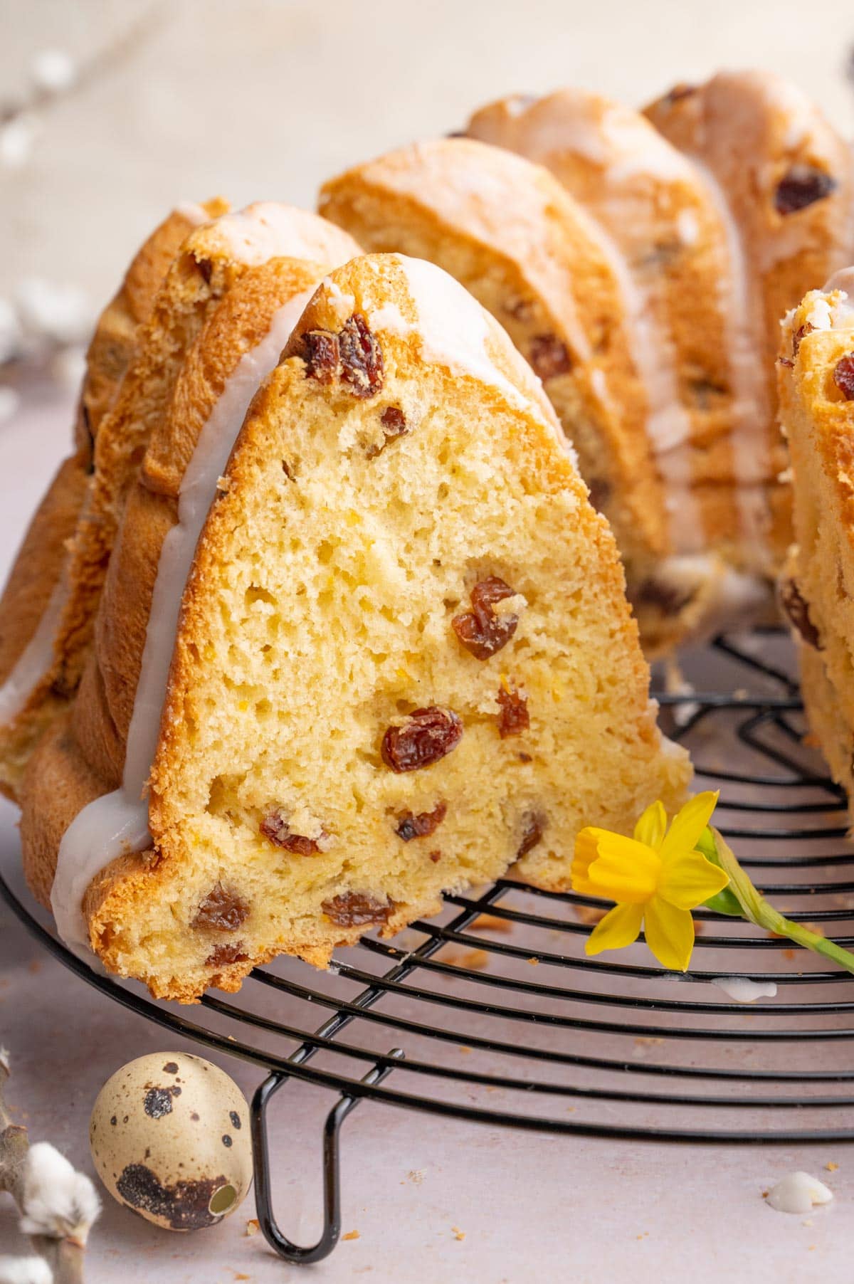 Raisin babka on a cooling rack with a piece missing.