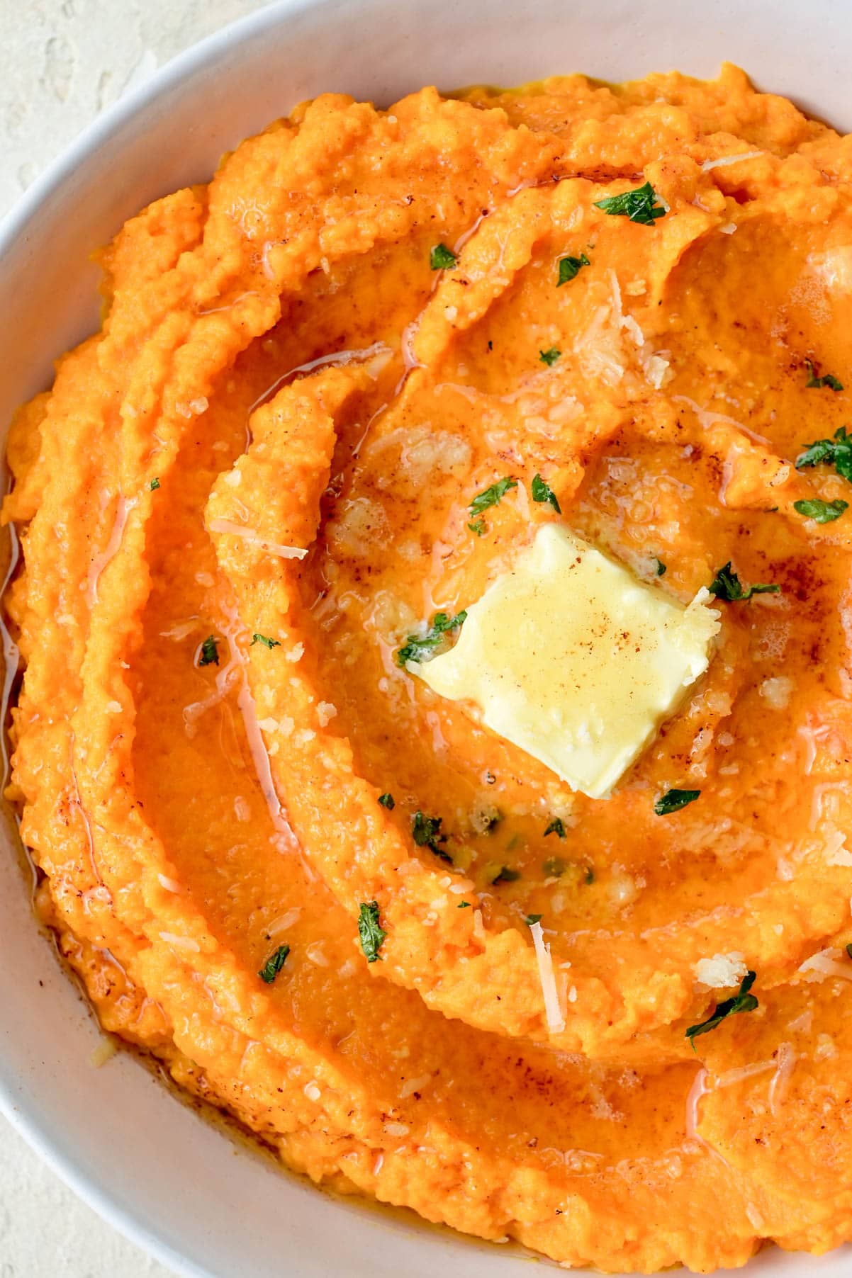 Mashed carrots in a white bowl.