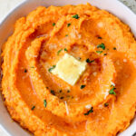 Mashed carrots in a white bowl.