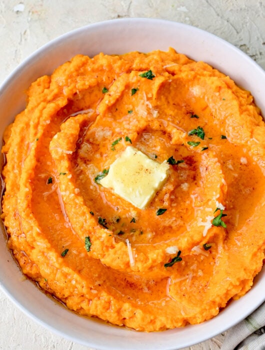 Mashed carrots in a white bowl.