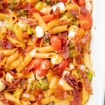 Cheesy Tomato Broccoli Pasta with Crispy Prosciutto in a white baking dish.