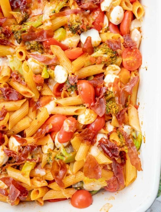 Cheesy Tomato Broccoli Pasta with Crispy Prosciutto in a white baking dish.