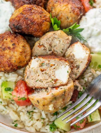 Greek chicken meatballs with rice and tzatziki on a plate.