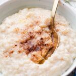 Milchreis in a white bowl topped with cinnamon sugar.