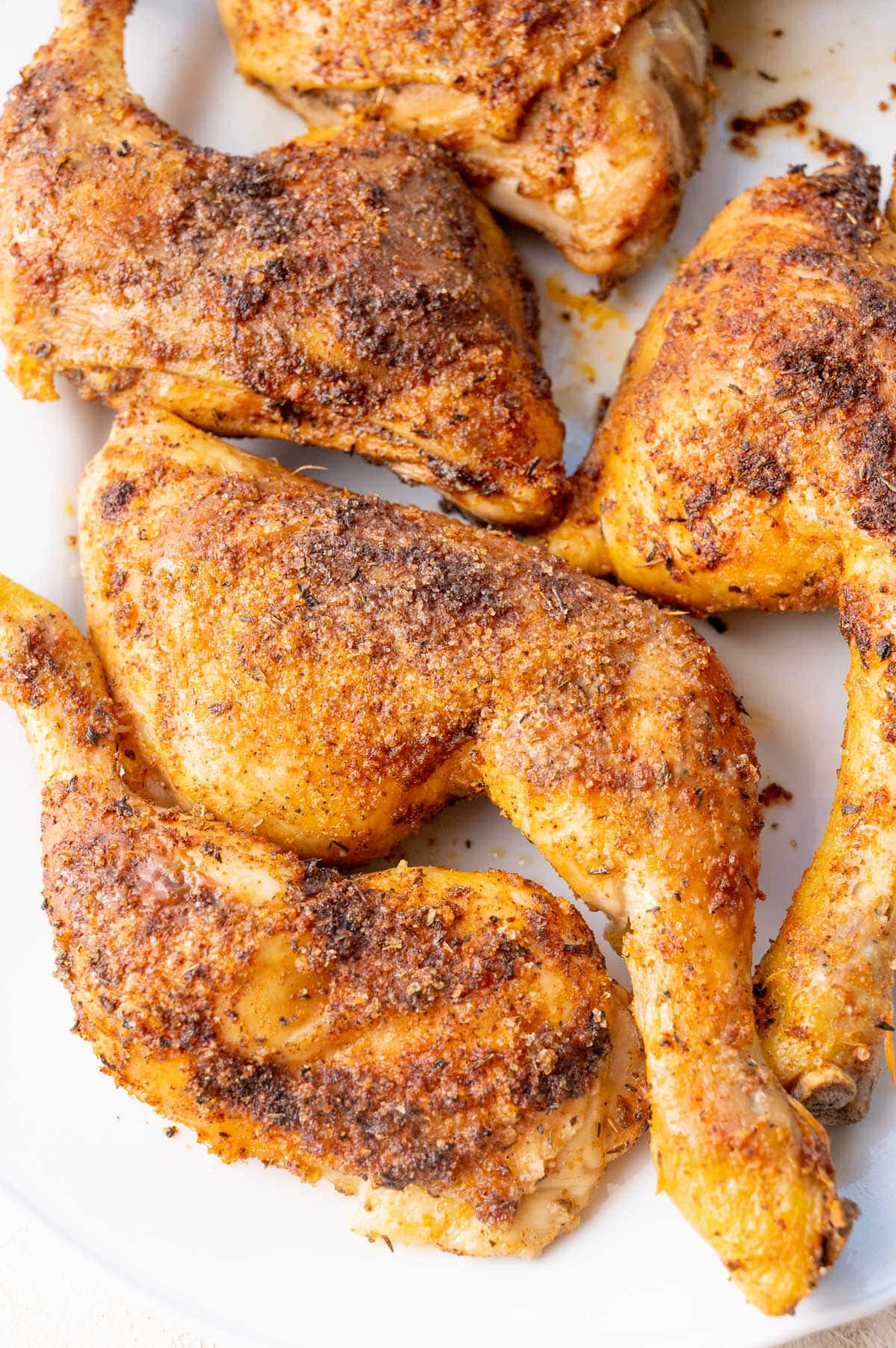 Baked Chicken Leg Quarters on a white serving plate.