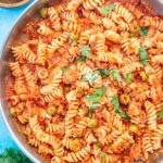 Tuna pasta with tomatoes and olives in a large frying pan.