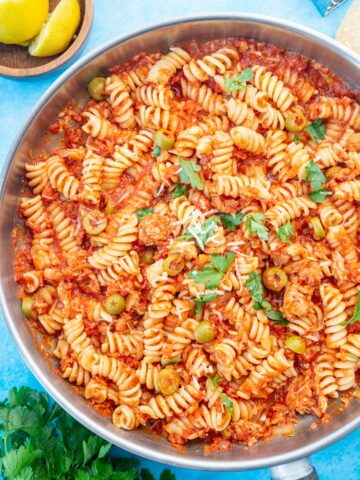 Tuna pasta with tomatoes and olives in a large frying pan.