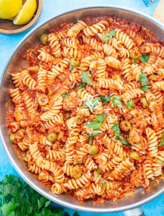 Tuna pasta with tomatoes and olives in a large frying pan.