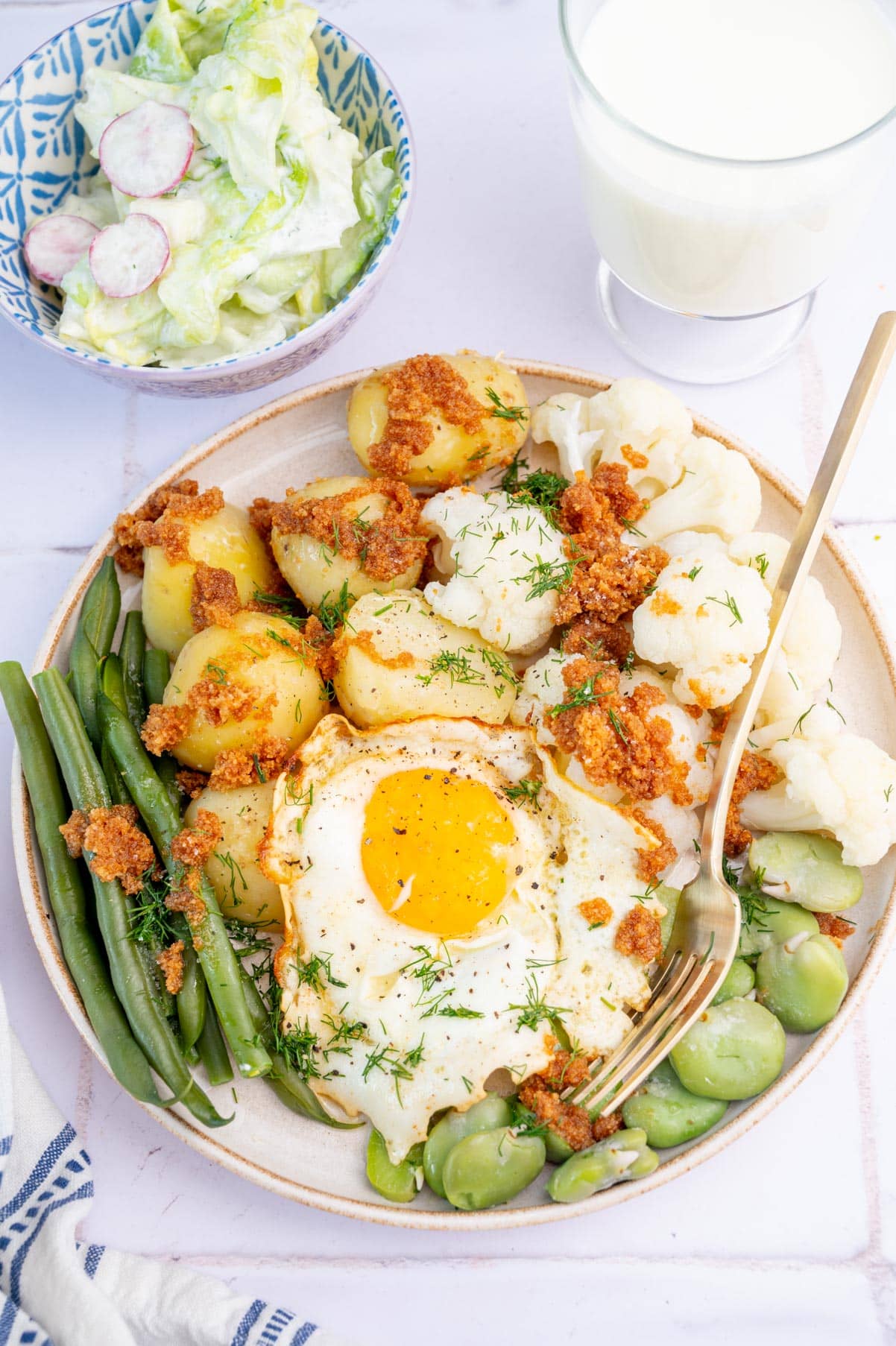 Summer vegetables, sunny-side-up egg, buttered breadcrumbs, butter lettuce salad and kefir.