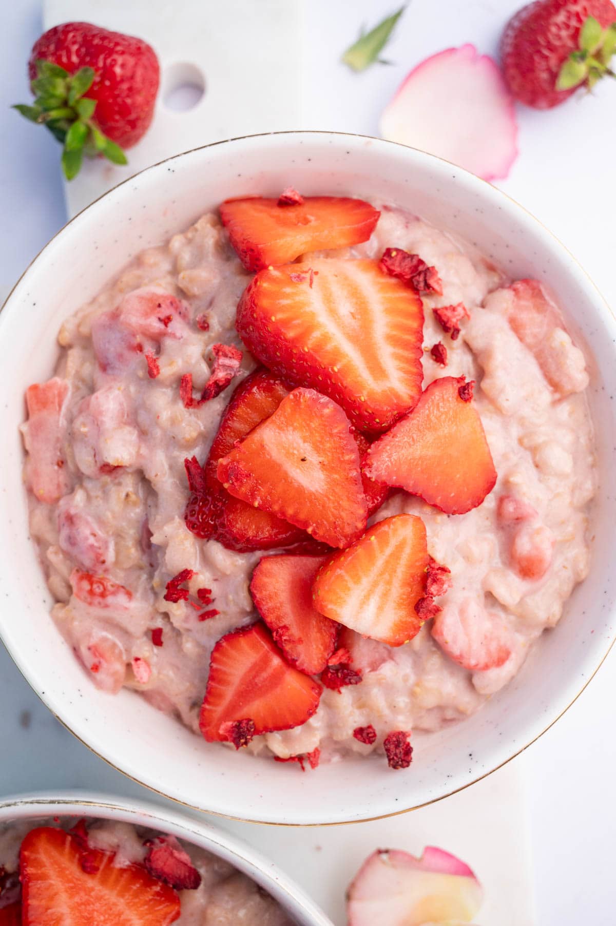 An overhead photo of strawberries and cream oatmeal with sliced strawberries on top.