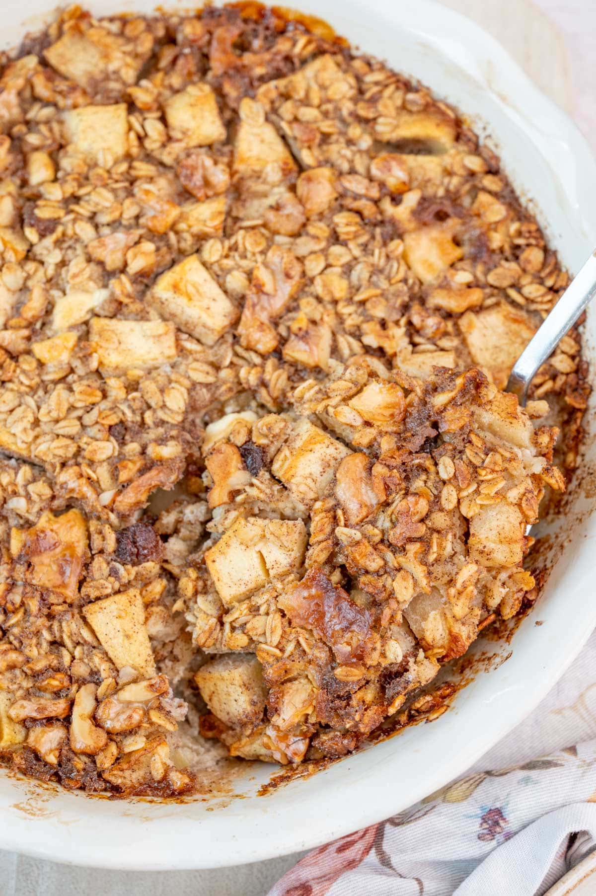 A close-up photo of apple baked oatmeal in a white baking dish.