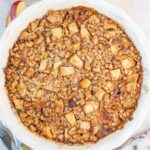 Baked apple oatmeal in a white baking dish.