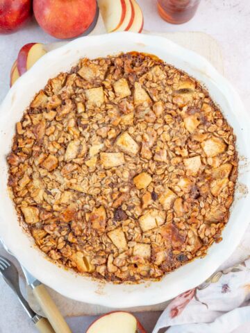 Baked apple oatmeal in a white baking dish.