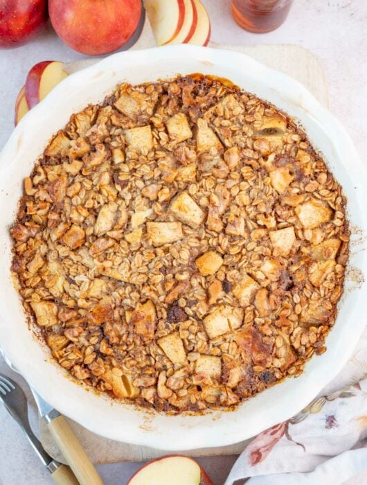 Baked apple oatmeal in a white baking dish.