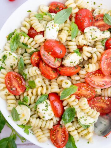Caprese pasta salad in a white bowl.