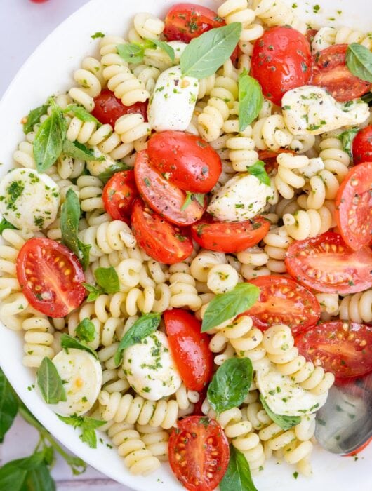 Caprese pasta salad in a white bowl.