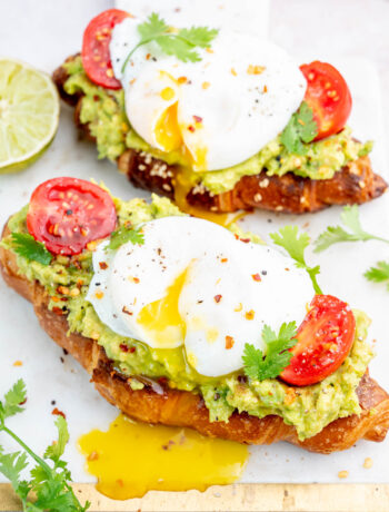 Avocado egg toast on a white board.