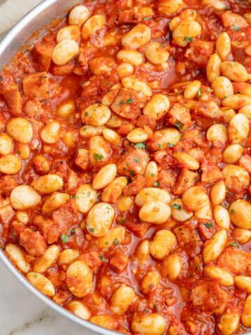 Polish beans and sausage in a frying pan.