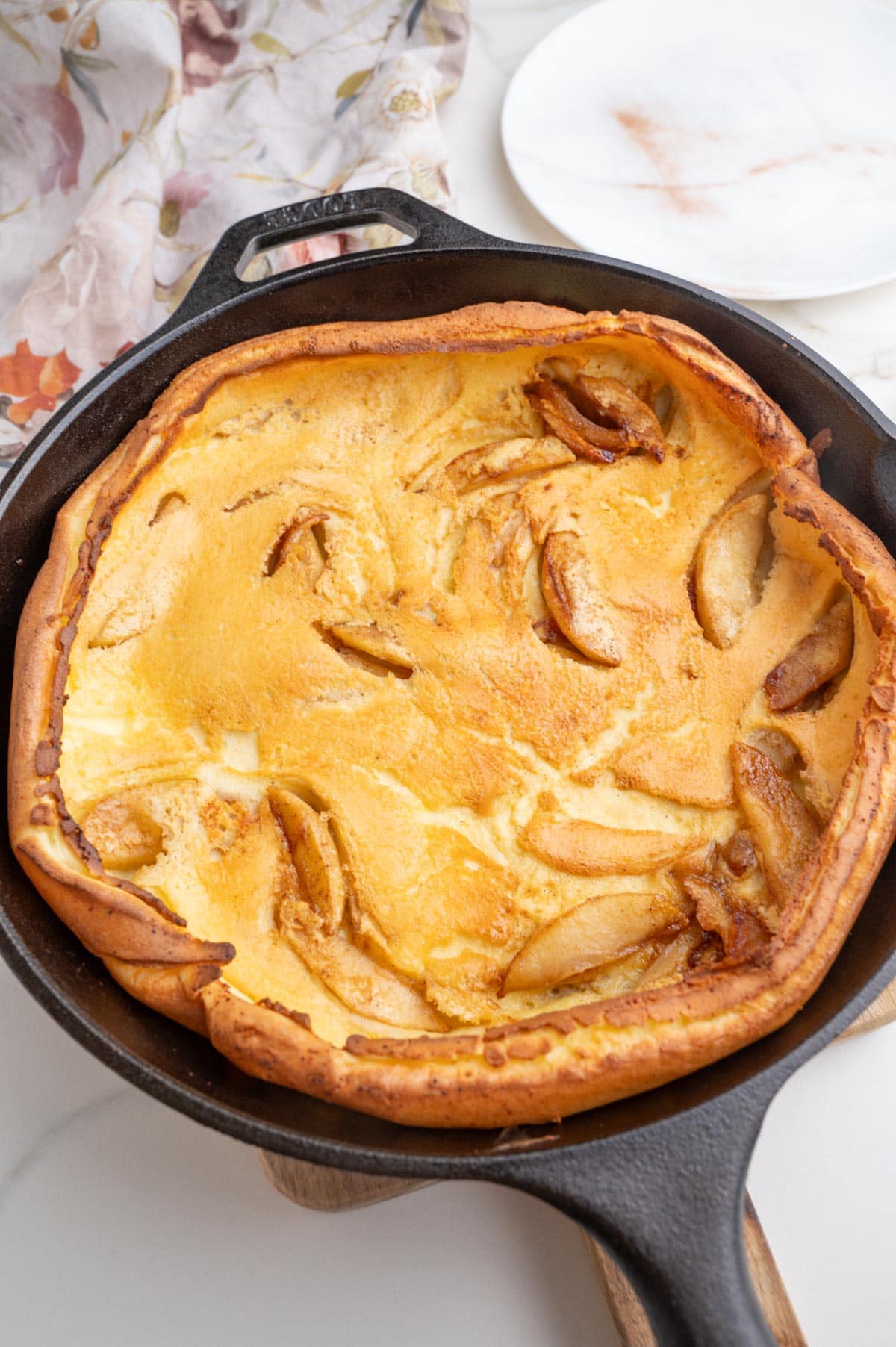 An overhead photo of German apple pancake in a cast iron pan.