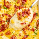 Loaded mashed potato casserole in a white baking dish.