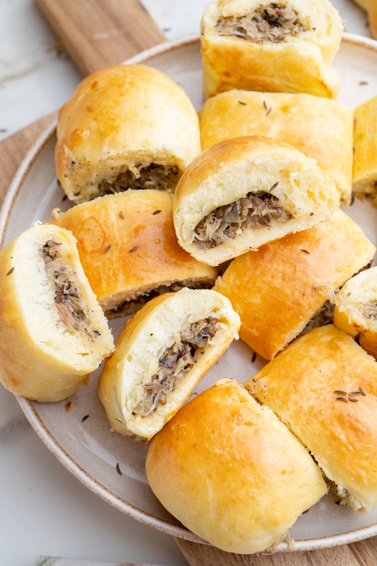 A close up photo of Sauerkraut and Mushroom Buns on a beige plate.