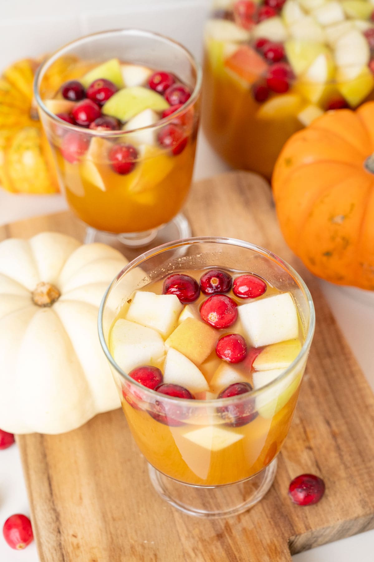 Two glasses with Thanksgiving sangria on a wooden board.