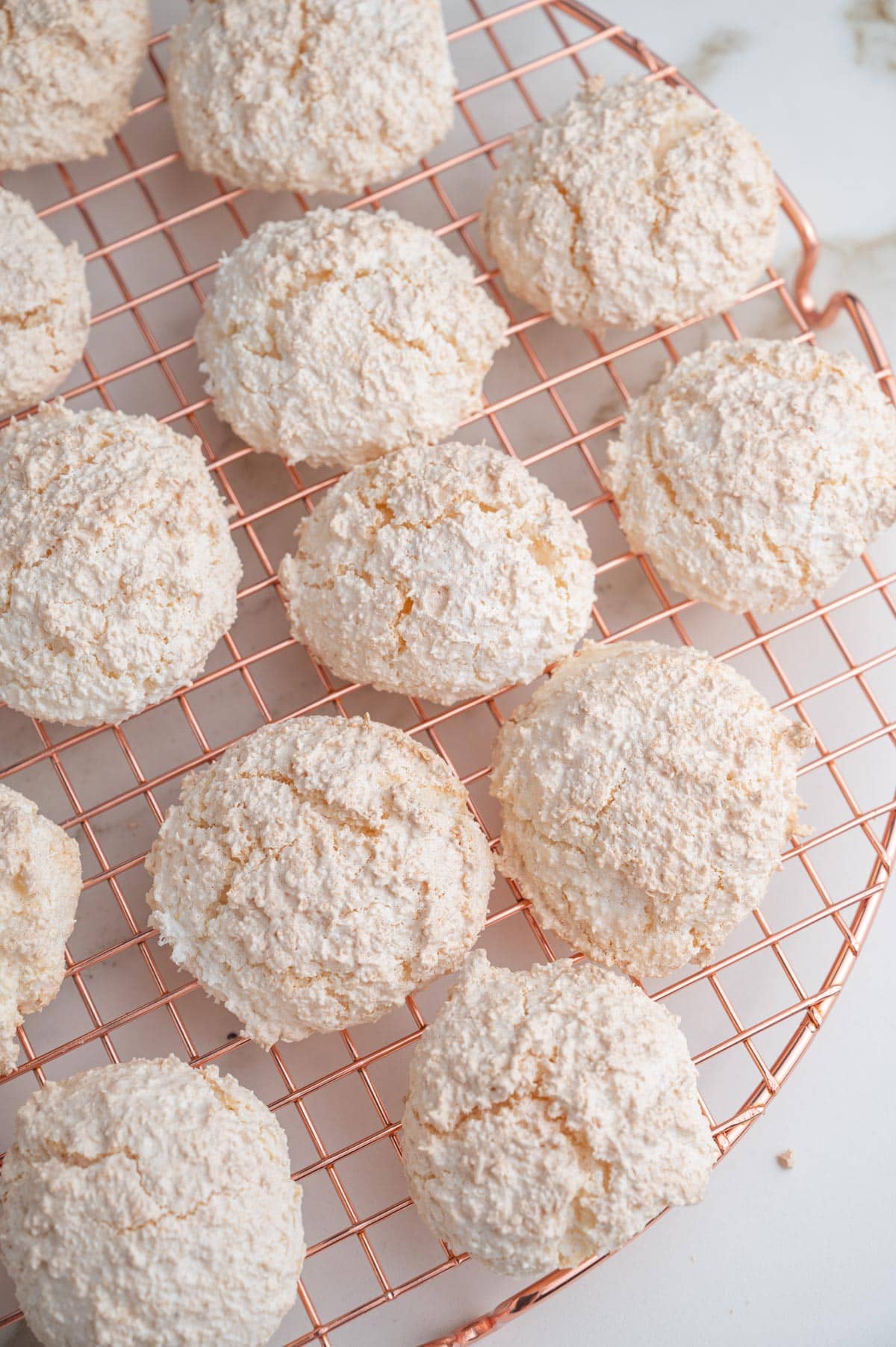 Kokosmakronen on a gold cooling rack.