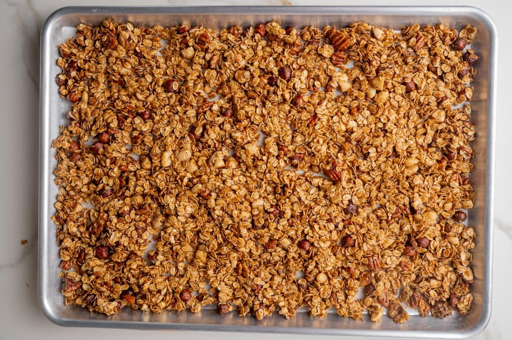 Gingerbread granola ready to be baked on a baking sheet.